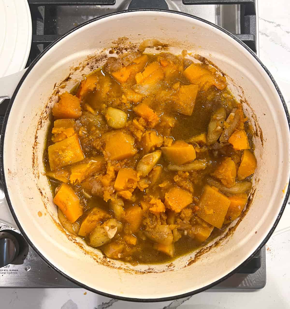 Butternut squash soup in a pot after simmering for an hour.