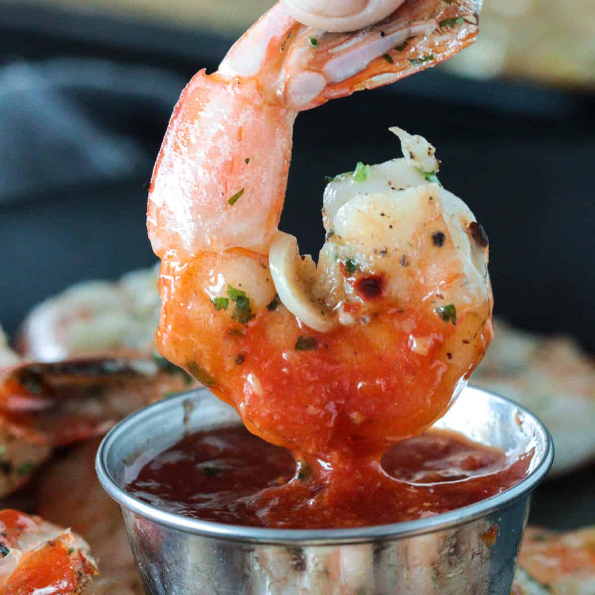 Shrimp cocktail being dipped into cocktail sauce.