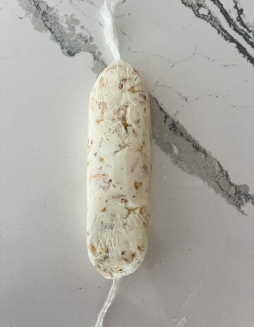 Goat cheese in a saran wrap.