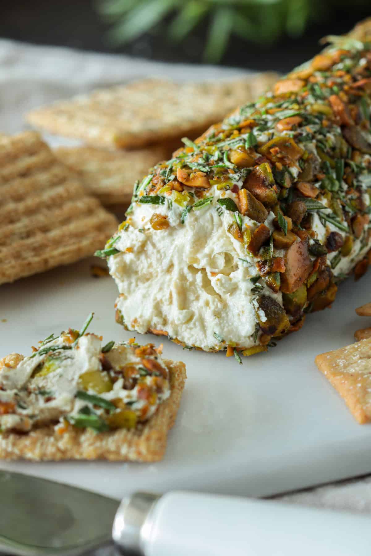 Goat cheese log spread onto crackers.