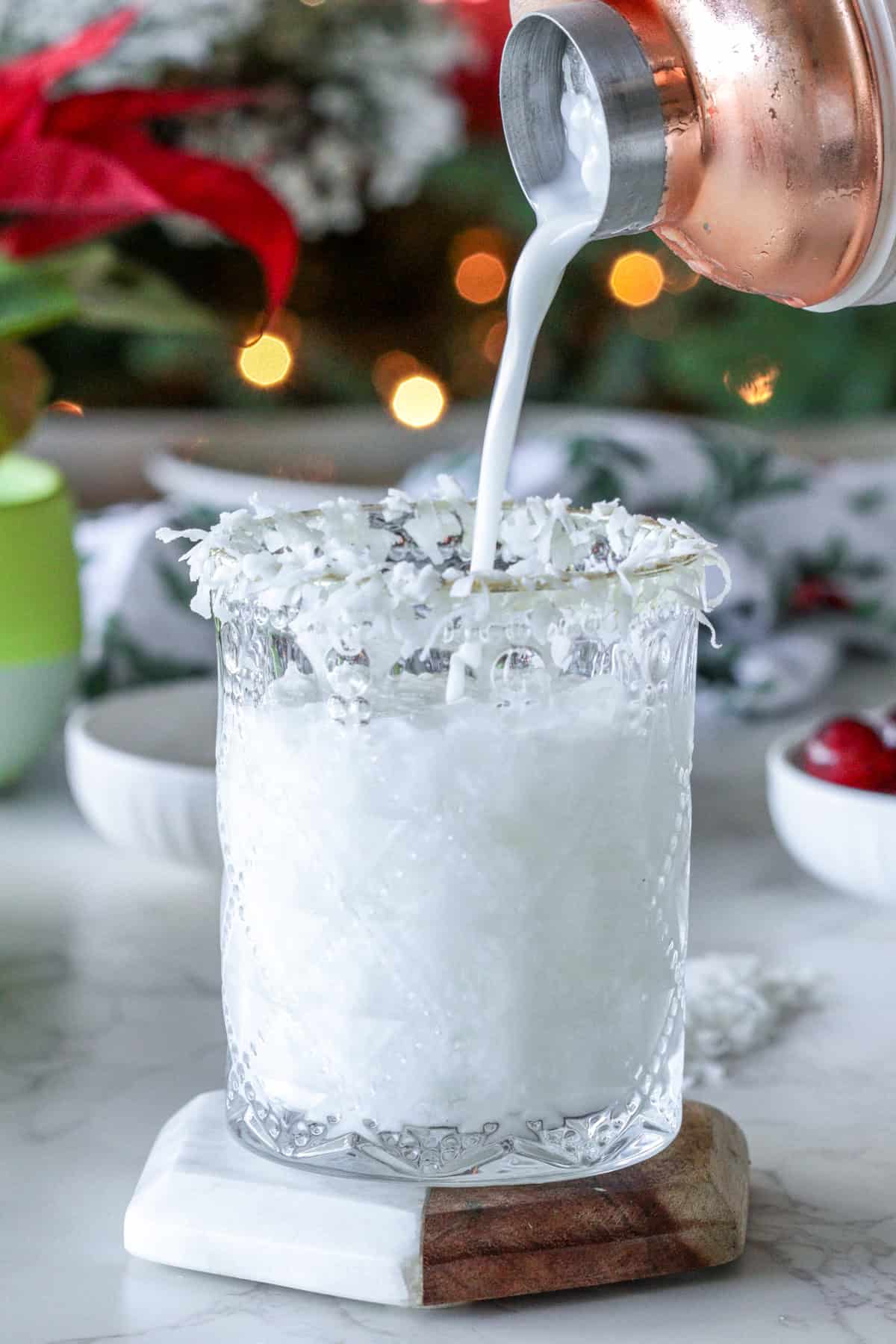 Pouring a white winter margarita into glass.