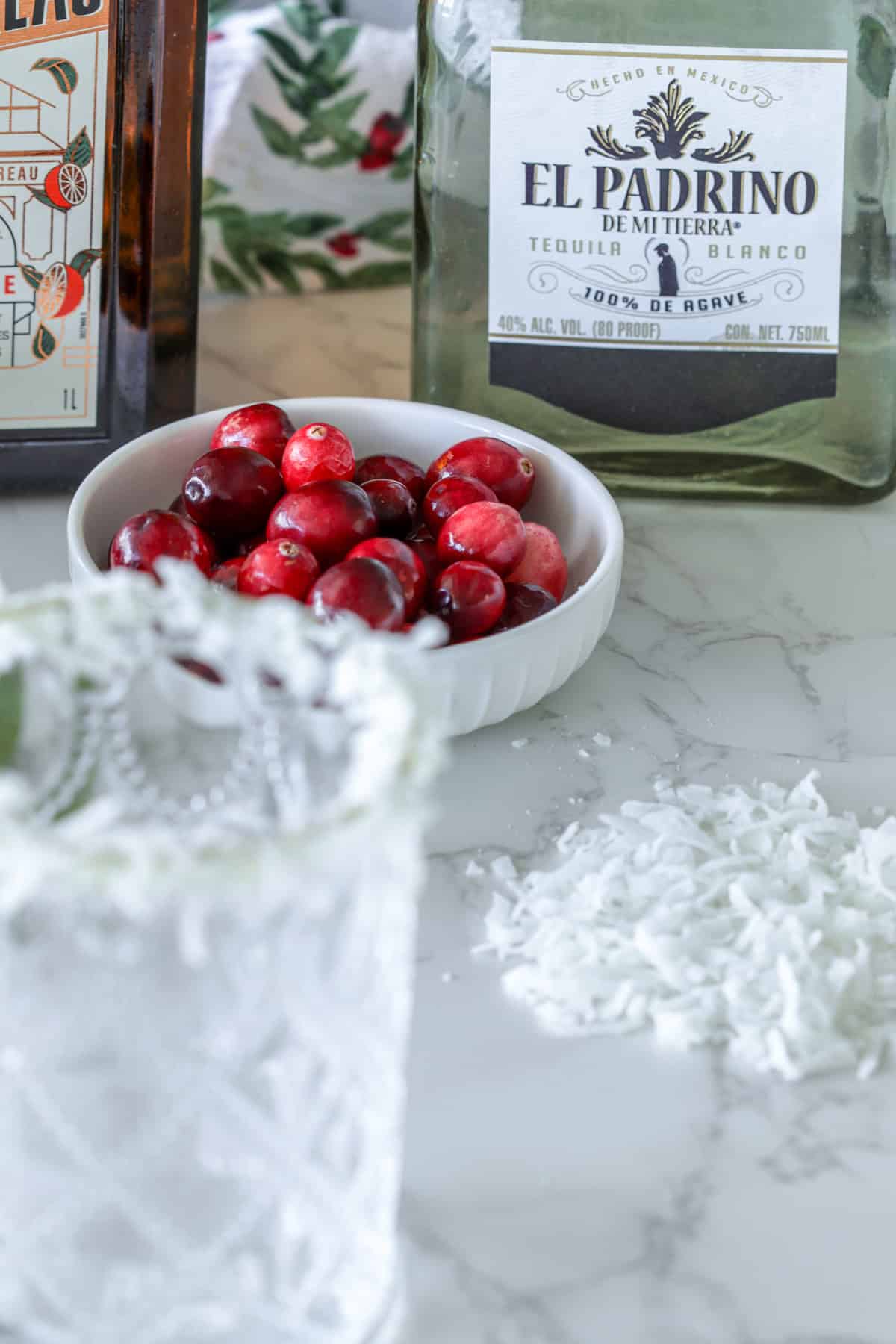 Cranberries and tequila on table.