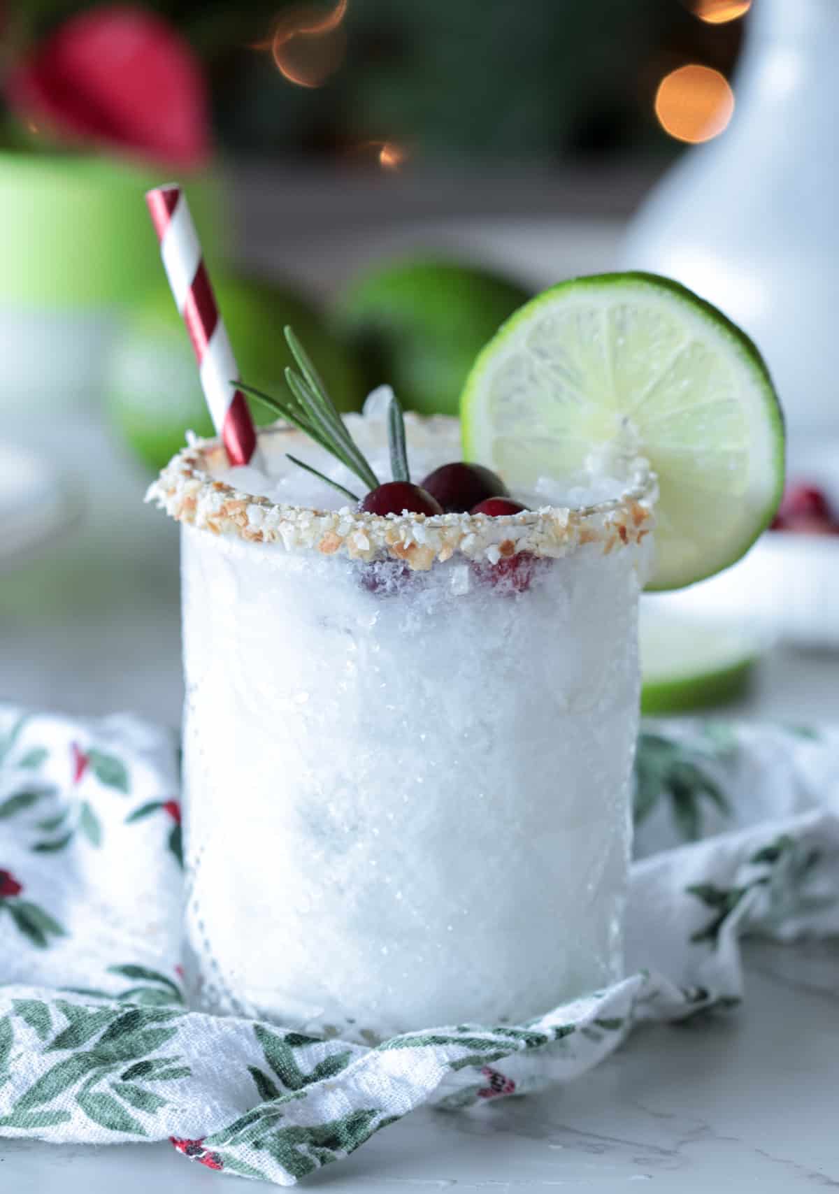 White margarita on table with straw and lime wheel.