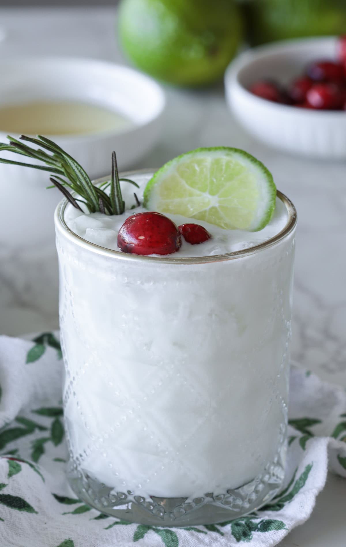 White margarita with lime and cranberry garnish.