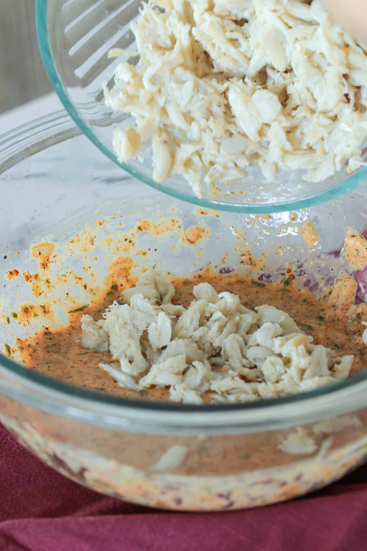 Adding crab meat to bowl.