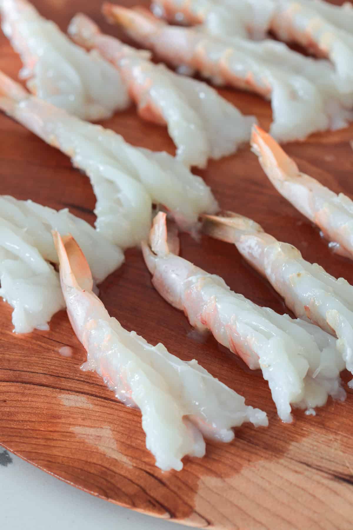 Butterflied shrimp on cutting board.