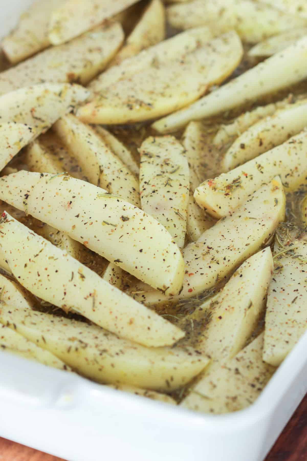 Greek potatoes in Greek seasoning before baking.