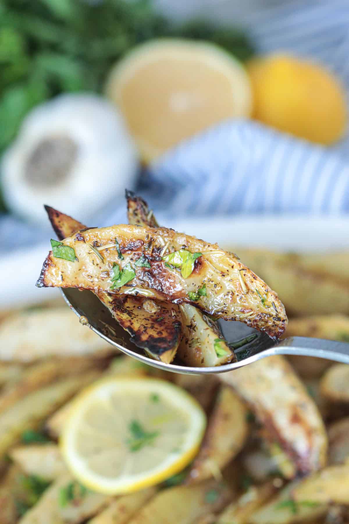 Greek lemon potatoes in a serving spoon.