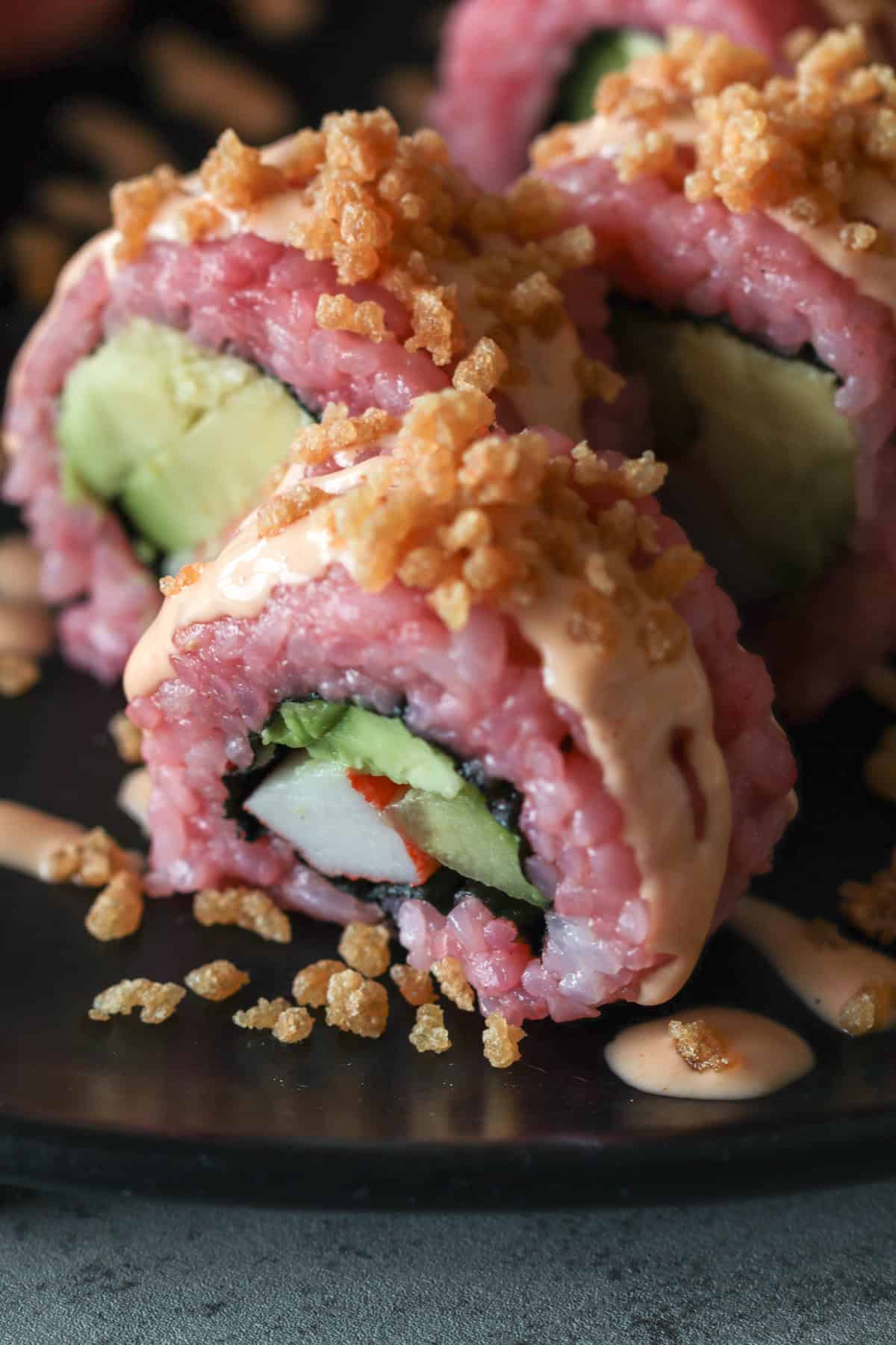 Pink sushi with crunch on top and krab and cucumber.