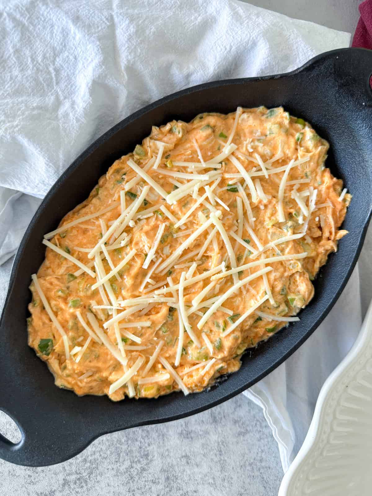 Buffalo chicken dip in a cast iron skillet before baking.