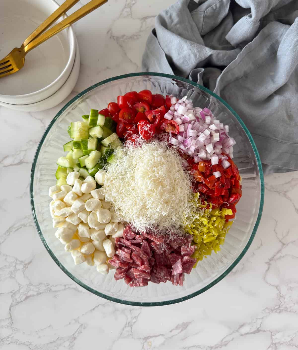 Pasta salad ingredients chopped in a bowl.