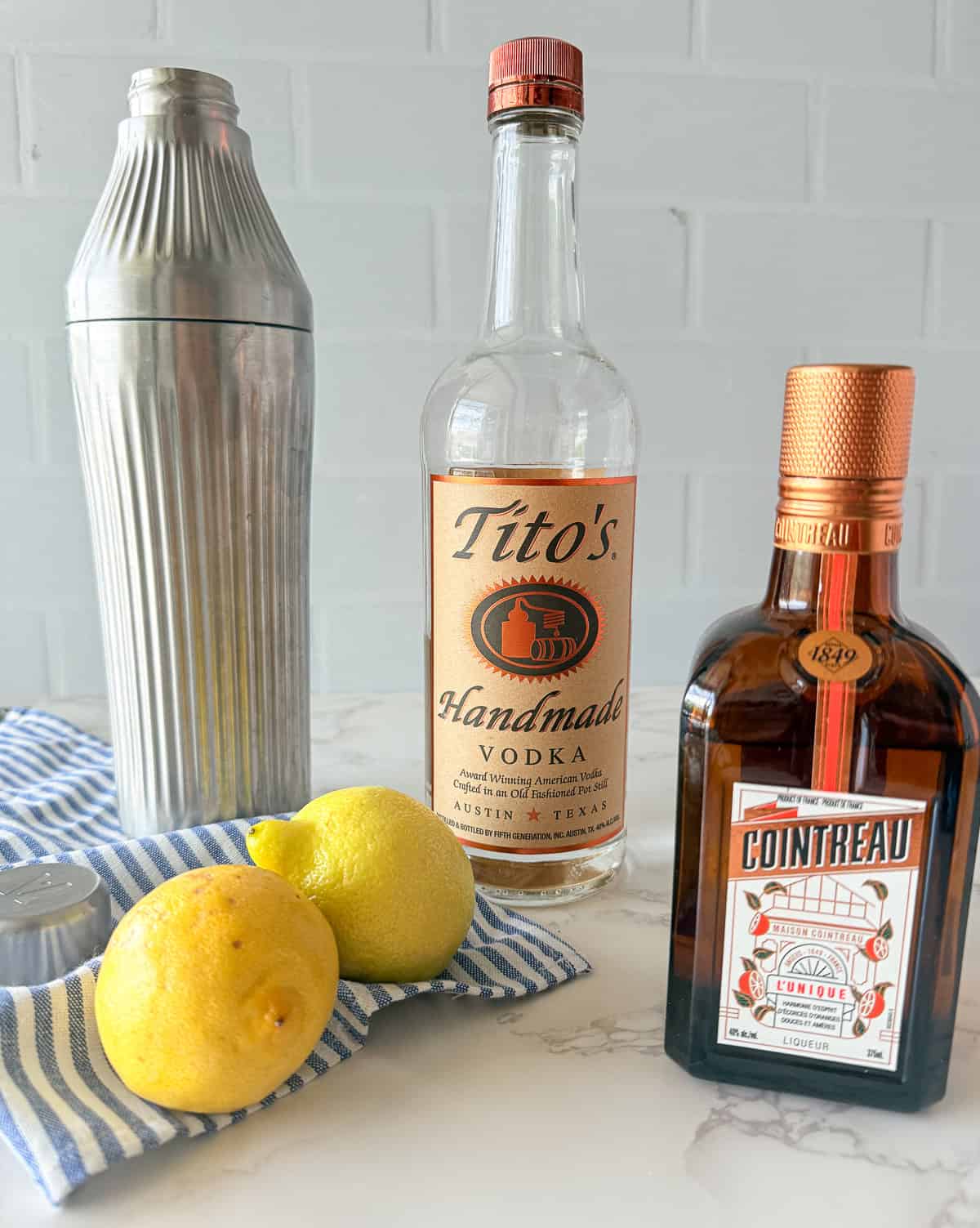 Vodka, cointreau and lemons on table.