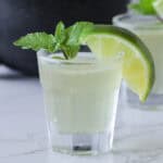 Green tea shot with a lime wedge.