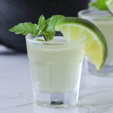Green tea shot with a lime wedge.