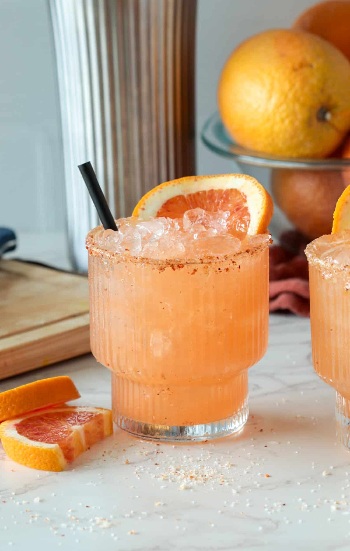 Blood orange margarita with a straw.