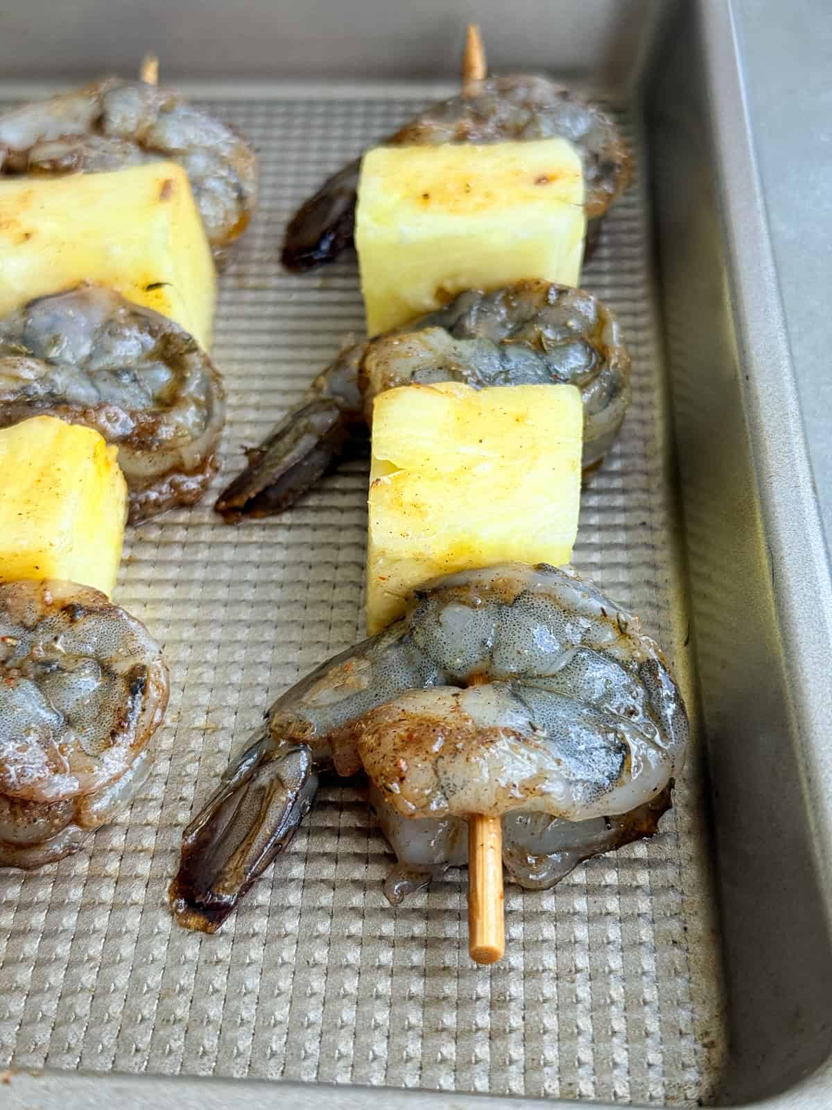 Pineapple and raw shrimp skewered.