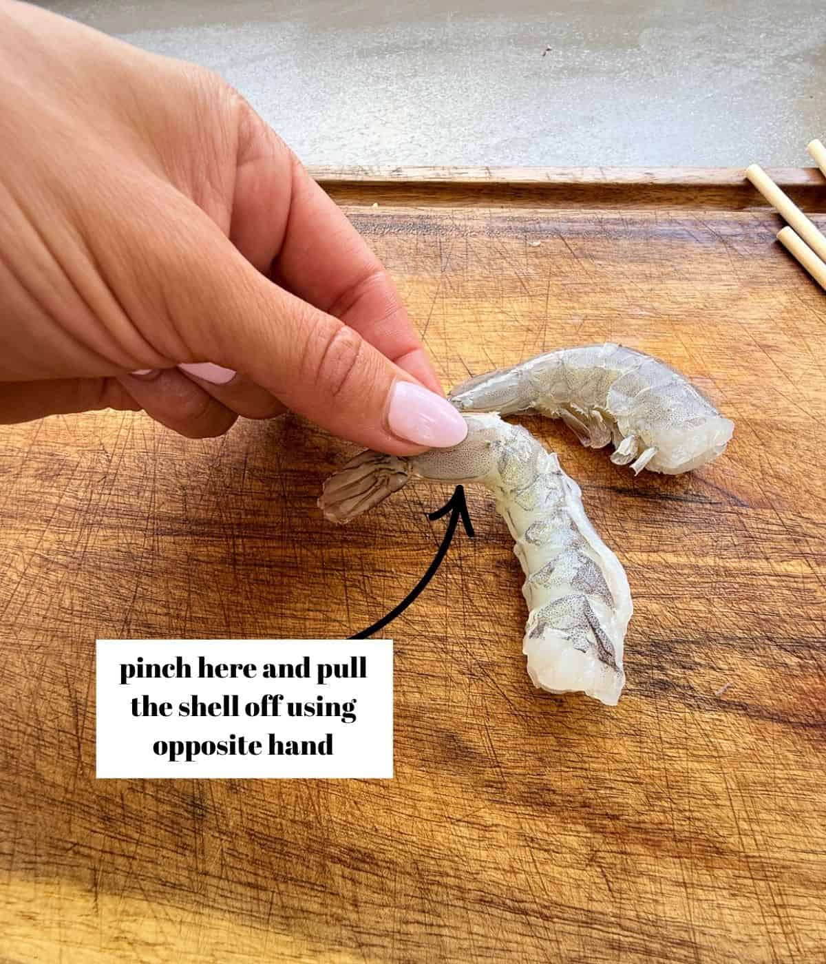 Peeling shell off shrimp.