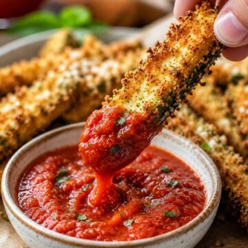 Crispy golden air fryer zucchini fries coated in parmesan panko breadcrumbs served with marinara dipping sauce