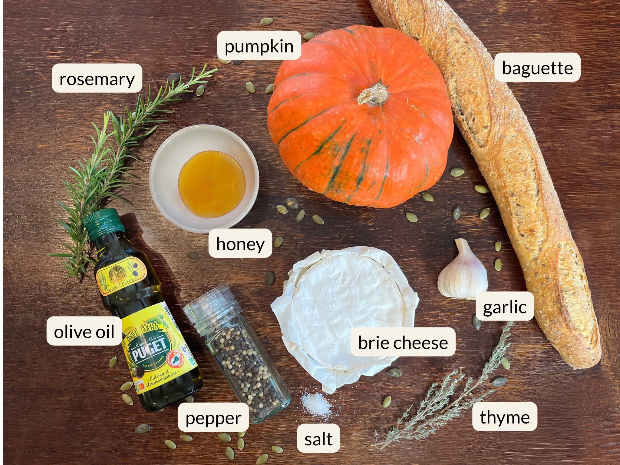 Ingredients for pumpkin Brie fondue including Brie, pumpkin, baguette, honey, garlic, rosemary and thyme.
