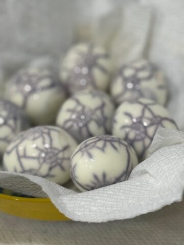 Peeled hard-boiled eggs showing dark spiderweb patterns